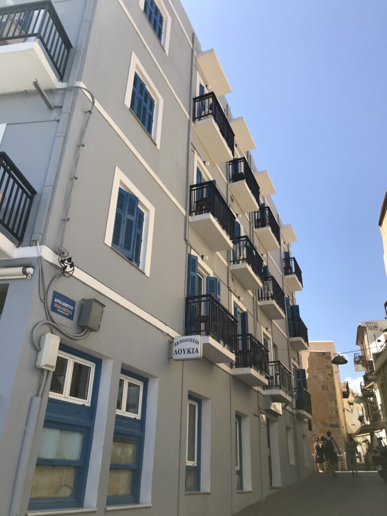 Traditional guesthouse building with blue shutters and balconies in Chania, Crete, Greece